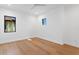 Bright, minimalist bedroom with hardwood floors, white walls, a ceiling fan, and natural light from two windows at 2087 Michigan Ne Ave, St Petersburg, FL 33703
