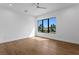 Minimalist bedroom with hardwood floors, white walls, and a large window showcasing natural light at 2087 Michigan Ne Ave, St Petersburg, FL 33703