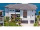 Beautiful modern waterfront home featuring a two-car garage, well-maintained lawn, and lush palm trees at 2087 Michigan Ne Ave, St Petersburg, FL 33703