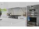 Modern kitchen with stainless steel appliances, white cabinets, and a marble backsplash at 2087 Michigan Ne Ave, St Petersburg, FL 33703