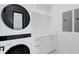 Laundry room with a stackable washer and dryer, storage cabinets, and a counter at 2087 Michigan Ne Ave, St Petersburg, FL 33703