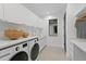 Bright laundry room featuring front loading washer/dryer, white cabinets, and modern fixtures at 2087 Michigan Ne Ave, St Petersburg, FL 33703