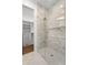 Glass enclosed shower stall featuring marble tiling and built-in shelves at 2087 Michigan Ne Ave, St Petersburg, FL 33703