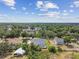 Aerial perspective of homes nestled among dense trees and blue skies with clouds at 2202 Colewood Ln, Dover, FL 33527