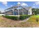 Spacious backyard featuring a screened-in pool area with lush landscaping and a well-maintained lawn at 2202 Colewood Ln, Dover, FL 33527