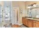 Bathroom featuring natural wood cabinets, granite countertop, and glass shower at 2202 Colewood Ln, Dover, FL 33527