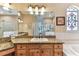 Well-lit bathroom with a large vanity, granite countertop, and stained glass window at 2202 Colewood Ln, Dover, FL 33527