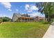 Attractive home featuring a spacious lawn, mature trees, covered porch, and inviting curb appeal at 2202 Colewood Ln, Dover, FL 33527