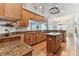 Open kitchen features wooden cabinets, granite countertops, stainless steel appliances, and center island at 2202 Colewood Ln, Dover, FL 33527