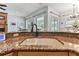 Close up of kitchen sink and granite countertops with a view to Gathering room and backyard at 2202 Colewood Ln, Dover, FL 33527