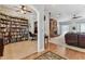 View of the living room featuring a fireplace and built-in bookcase with wood trim details and ceiling fan at 2202 Colewood Ln, Dover, FL 33527