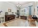 Bright living room features tile flooring, a piano, large windows and a decorative chandelier at 2202 Colewood Ln, Dover, FL 33527