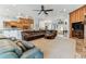 Spacious living room featuring a large sectional sofa, hardwood floors, and view of the fireplace and kitchen at 2202 Colewood Ln, Dover, FL 33527