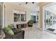 Relaxing sunroom featuring tile floors, lots of natural light, and comfortable wicker seating with green cushions at 2202 Colewood Ln, Dover, FL 33527