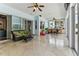 Bright sunroom with tile floors, glass sliding doors, ceiling fans, and a comfortable seating area at 2202 Colewood Ln, Dover, FL 33527