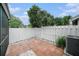 Paver patio in the backyard with a white fence, landscaping, and partial view of house and lanai at 2456 Alhambra St, Clearwater, FL 33761