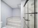 This bathroom has a shower stall with glass door and a soaking tub with tile surround at 2456 Alhambra St, Clearwater, FL 33761
