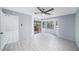 Bright bedroom features wood-look floors, a ceiling fan, and sliding glass door to a screened patio at 2456 Alhambra St, Clearwater, FL 33761