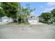 Exterior of the home with a two-car garage, mature landscaping, and a manicured lawn on a sunny day at 2456 Alhambra St, Clearwater, FL 33761