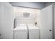 Laundry room with side-by-side washer and dryer, white wire shelving, and bi-fold doors at 2456 Alhambra St, Clearwater, FL 33761