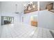 Open-concept living space featuring tile flooring, staircase, chandelier, and sliding glass door to patio at 2456 Alhambra St, Clearwater, FL 33761