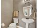 Elegant powder room featuring stylish wallpaper, an oval mirror, and a sleek pedestal sink at 2614 Brookforest Dr, Wesley Chapel, FL 33544