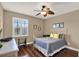 Cozy bedroom with hardwood floors, white iron bed frame, and natural light from the window at 2614 Brookforest Dr, Wesley Chapel, FL 33544