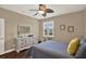 Cozy bedroom features a gray quilt, white dresser, and a modern ceiling fan at 2614 Brookforest Dr, Wesley Chapel, FL 33544