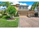 Stunning two-story house with a three-car garage, a paver driveway, and lush landscaping at 2614 Brookforest Dr, Wesley Chapel, FL 33544