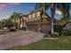 Beautiful two-story home with a three-car garage and a brick driveway, complemented by lush landscaping and palm trees at 2614 Brookforest Dr, Wesley Chapel, FL 33544