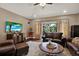 Open concept living room with leather furniture, TV, and hardwood floors at 2614 Brookforest Dr, Wesley Chapel, FL 33544