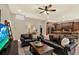Open-concept living room with leather sofas, dark wood accents, and seamless flow to kitchen at 2614 Brookforest Dr, Wesley Chapel, FL 33544