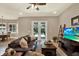 Inviting living room with leather seating, ceiling fan, and view of the pool area at 2614 Brookforest Dr, Wesley Chapel, FL 33544