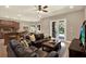 Cozy living room featuring leather sofas, a ceiling fan, and view to the outdoor pool through French doors at 2614 Brookforest Dr, Wesley Chapel, FL 33544