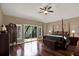 Bright main bedroom showcasing hardwood floors, ceiling fan, and balcony access at 2614 Brookforest Dr, Wesley Chapel, FL 33544
