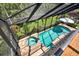 Aerial view of a screened-in pool and hot tub surrounded by brick pavers and lush landscaping at 2614 Brookforest Dr, Wesley Chapel, FL 33544