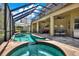 Screened pool area with a hot tub, patio, outdoor seating, and a second story balcony at 2614 Brookforest Dr, Wesley Chapel, FL 33544