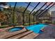 Relaxing screened-in pool and spa area with lush greenery, perfect for outdoor enjoyment at 2614 Brookforest Dr, Wesley Chapel, FL 33544