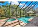 Screened-in pool and spa area surrounded by lush landscaping at 2614 Brookforest Dr, Wesley Chapel, FL 33544