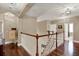Open hallway features hardwood floors, staircase and open layout to multiple rooms at 2614 Brookforest Dr, Wesley Chapel, FL 33544