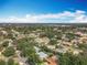 Community aerial view featuring mature trees, a mix of single-Gathering homes, and convenient access to city amenities in the distance at 2742 Sea Pines E Cir, Clearwater, FL 33761