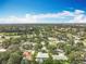 Wide aerial shot capturing a residential community with a golf course, mature trees, and well-maintained landscapes under a blue sky at 2742 Sea Pines E Cir, Clearwater, FL 33761