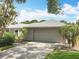Home with a 2-car garage, featuring a neutral exterior and lush landscaping at 2742 Sea Pines E Cir, Clearwater, FL 33761