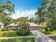 Charming single-story home with a well-manicured lawn, complemented by mature trees and lush landscaping at 2742 Sea Pines E Cir, Clearwater, FL 33761