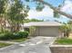 Home with a 2-car garage, featuring a neutral exterior and a manicured lawn at 2742 Sea Pines E Cir, Clearwater, FL 33761