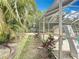 Exterior shot of the screened in pool with a slide and tropical landscaping at 2742 Sea Pines E Cir, Clearwater, FL 33761