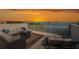 Serene rooftop deck with stylish seating, a fire pit, and picturesque sunset views over the water at 2750 Reserve Ct # 101, Dunedin, FL 34698
