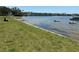 Grassy waterfront with views of the bay, a bench, and a small boat at 2750 Reserve Ct # 101, Dunedin, FL 34698