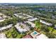 Aerial view of a multi-Gathering complex featuring a community pool and tennis court amidst lush greenery and parking areas at 2840 Somerset Park Dr # 203, Tampa, FL 33613