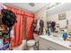 Compact bathroom features a vanity sink, mirrored cabinet, and shower with an orange curtain at 2840 Somerset Park Dr # 203, Tampa, FL 33613